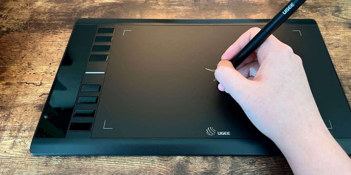 Hand using stylus on Ugee M708 Tablet  Hand using stylus on Ugee M708 Tablet