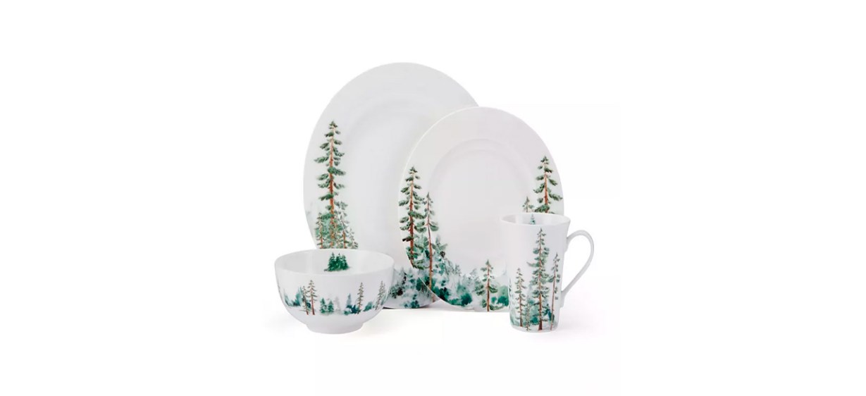 A set of white bowls, plates and mugs with images of evergreen forests on them