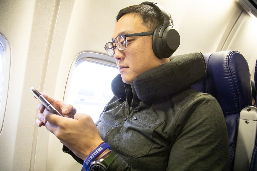 Man using headphones on plane