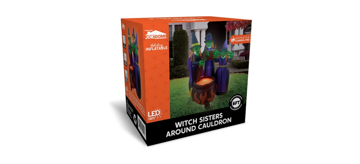An outdoor inflatable decoration of 3 witches standing around a cauldron with flames on it